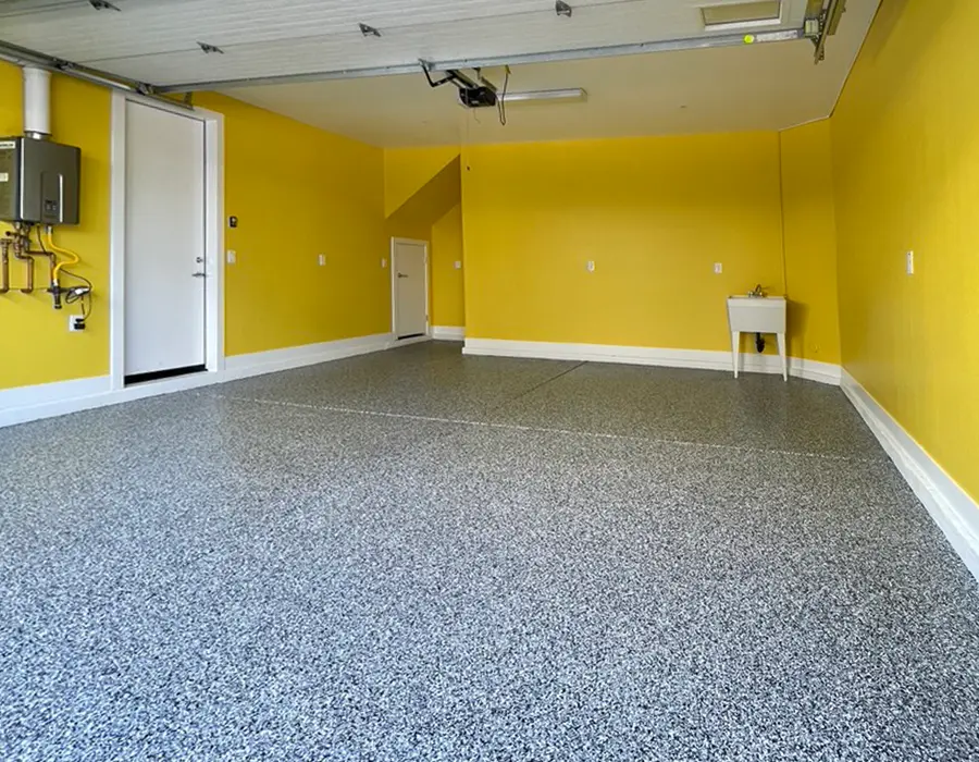 Gray epoxy flooring in a garage with bright yellow walls