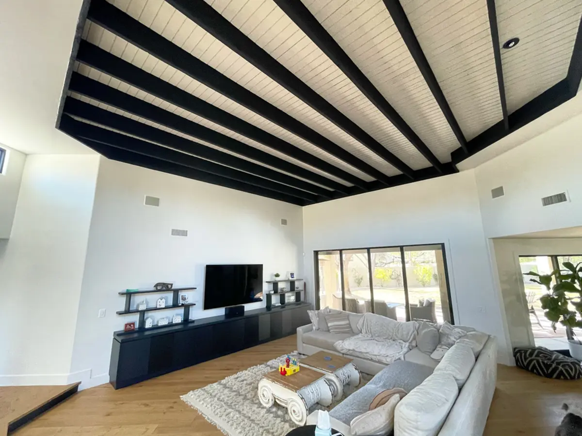 Interior painting from Orange Door with black exposed beams and black refinished furniture