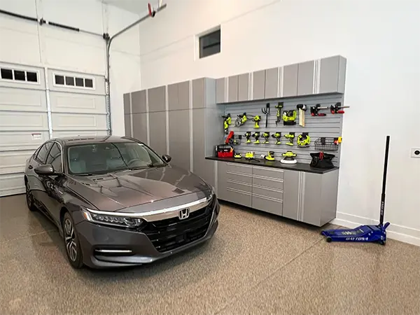 Tidy organized garage with custom storage and epoxy flooring