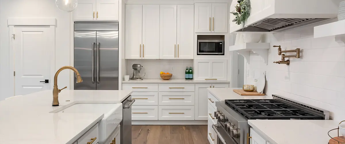Kitchen cabinets painted white with golden hardware